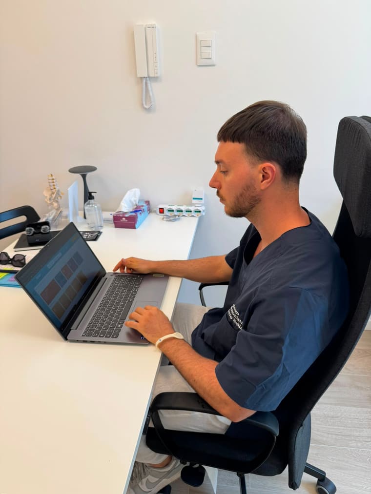 Lorenzo Nella alla scrivania del suo studio mentre elabora un piano alimentare al computer.