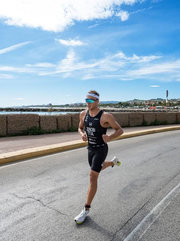 Atleta di endurance durante la frazione di corsa su strada, lungomare.